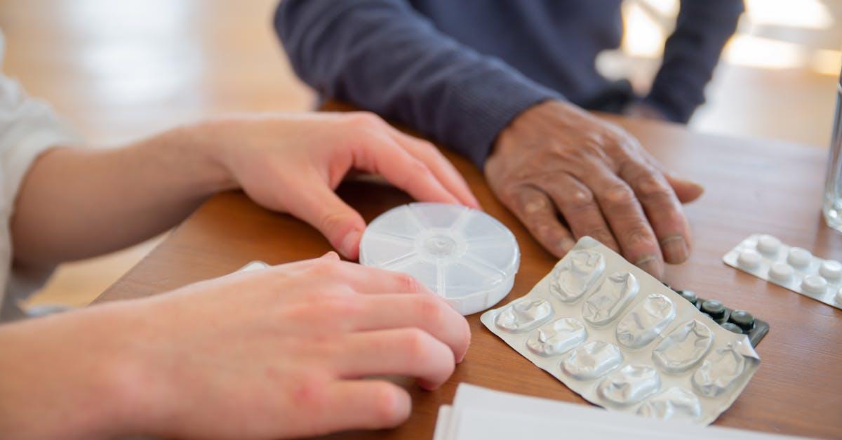 Empty medication blister pack on a table next to a phone
