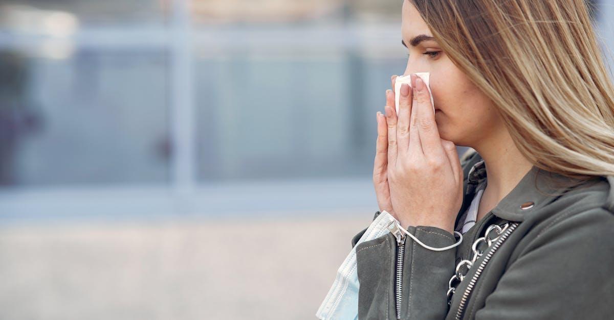Person sneezing outdoors in a park during spring in Wakefield